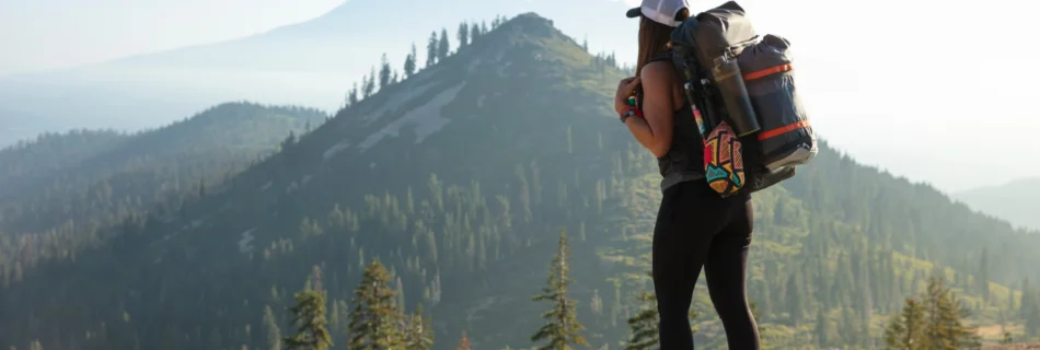 Hiker exploring a scenic Black Hills trail with a cozy cabin in the background